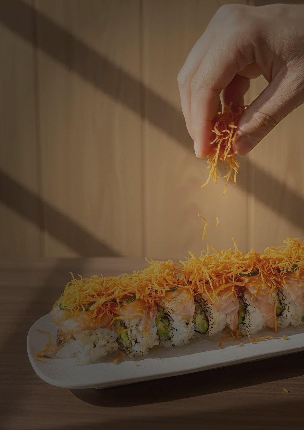Finishing a Bon Special Roll with a pinch of yam crunch